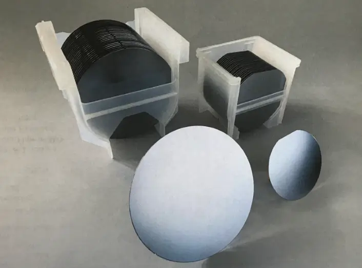 Two camera lenses and two spherical objects on a gray surface.